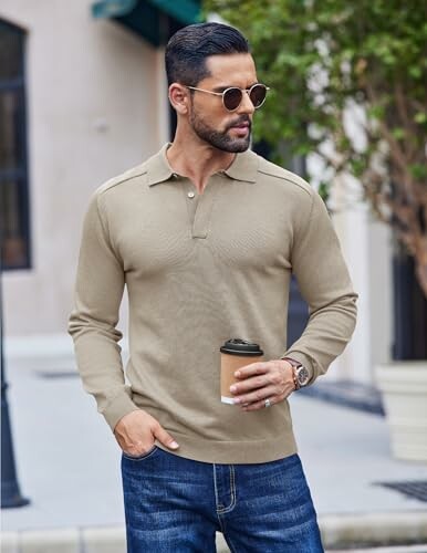 Man in sunglasses holding a coffee cup outdoors.